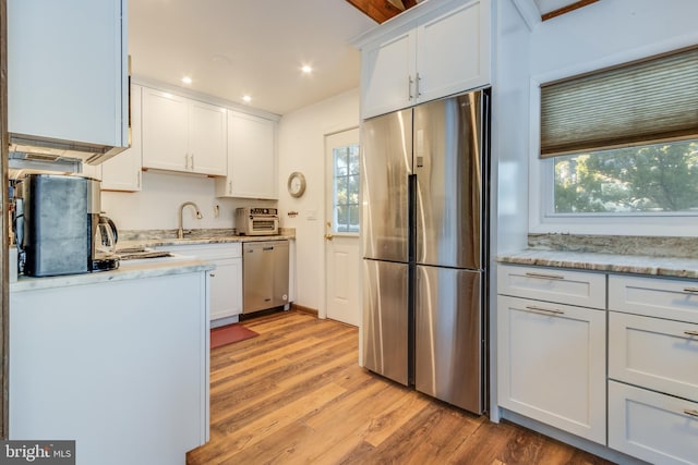 kitchen featuring white cabinetry, stainless steel appliances, and a healthy amount of sunlight