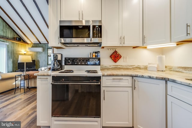 kitchen featuring range with electric cooktop, white cabinetry, and light stone countertops