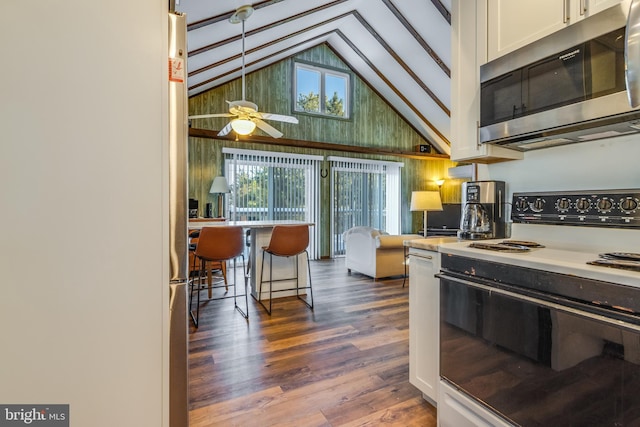 kitchen featuring plenty of natural light, dark wood-type flooring, white cabinets, and electric stove