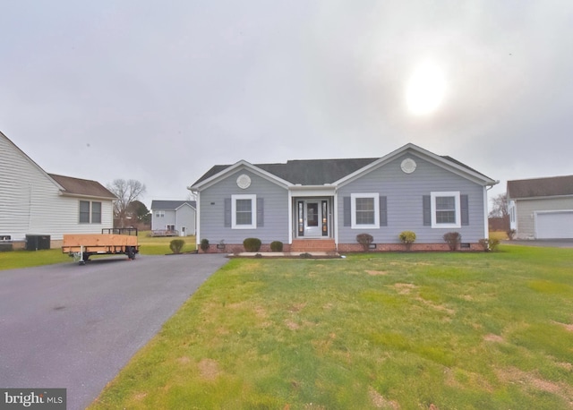 ranch-style home featuring a front lawn and central air condition unit