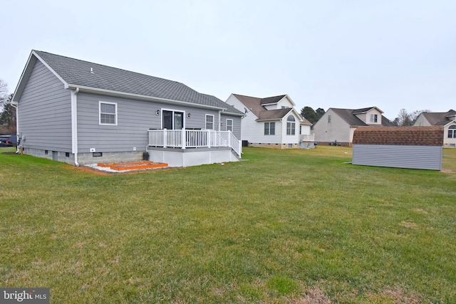 rear view of property featuring a lawn and a deck