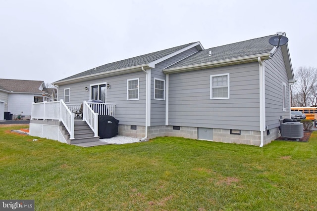 back of property featuring central air condition unit, a wooden deck, and a yard