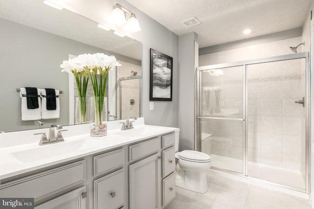 bathroom featuring a textured ceiling, vanity, toilet, and walk in shower