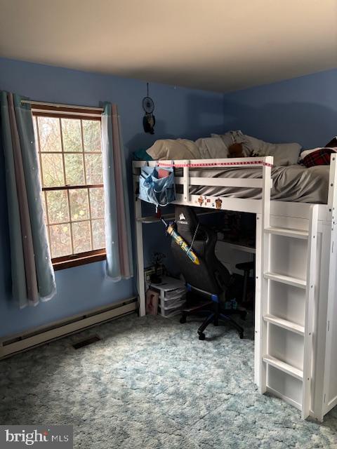 carpeted bedroom with a baseboard radiator