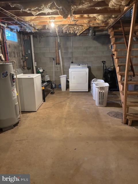 basement featuring washing machine and clothes dryer, electric panel, and water heater