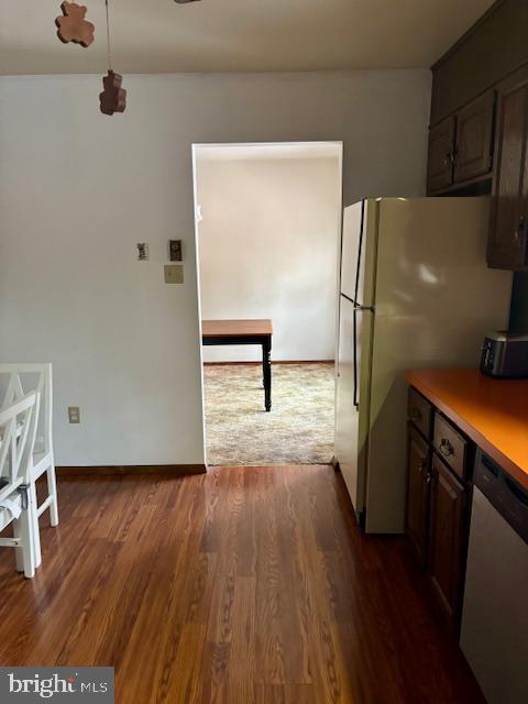 kitchen with dishwasher, dark brown cabinets, dark hardwood / wood-style flooring, and white refrigerator