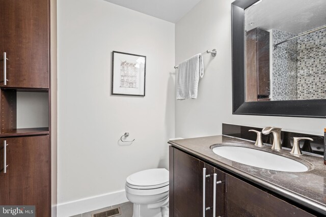 bathroom featuring walk in shower, tile patterned floors, vanity, and toilet