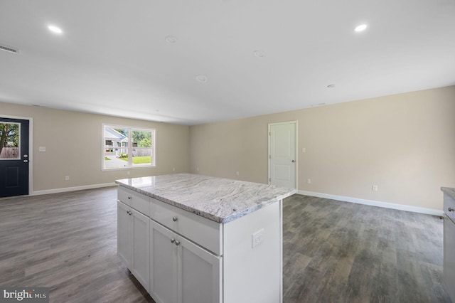 613 W 8th St, Laurel, DE 19956 - kitchen with open floor plan, a kitchen island, wood finished floors, white cabinets, and light stone counters