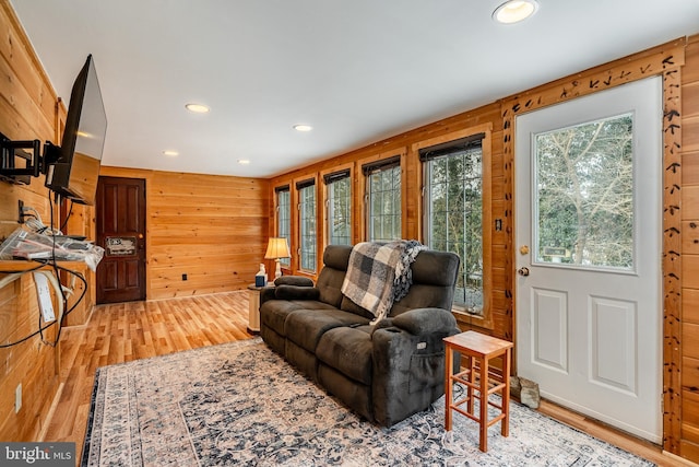 living room featuring hardwood / wood-style floors and wooden walls