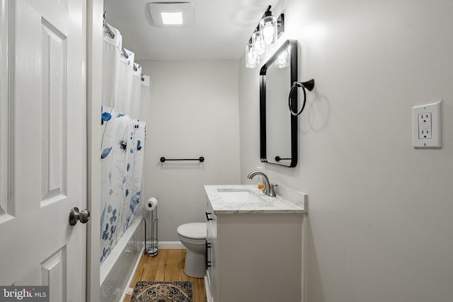 full bathroom with wood-type flooring, vanity, shower / tub combo, and toilet