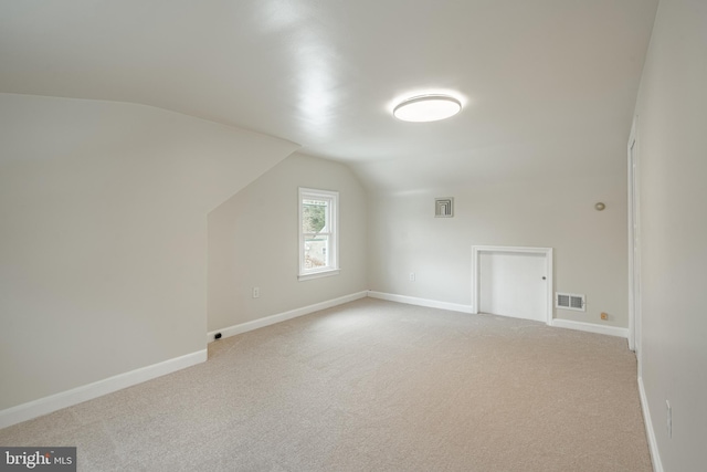 bonus room featuring light colored carpet and vaulted ceiling