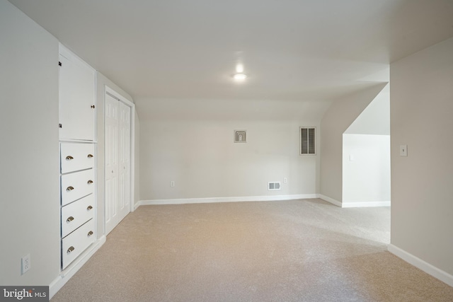 carpeted empty room with lofted ceiling