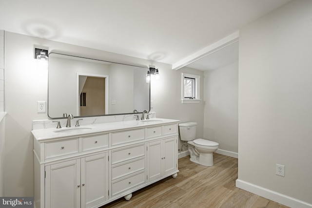 bathroom with wood-type flooring, vanity, and toilet