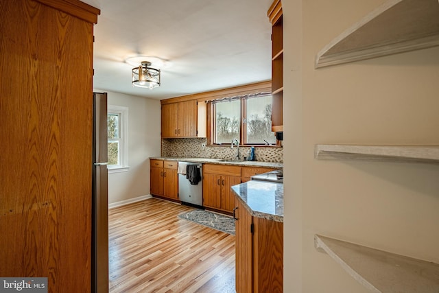 kitchen featuring decorative backsplash, sink, stainless steel appliances, and light hardwood / wood-style floors