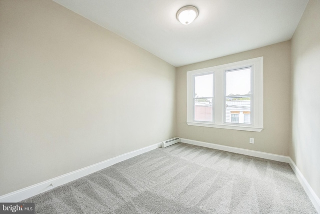 carpeted empty room with a baseboard heating unit