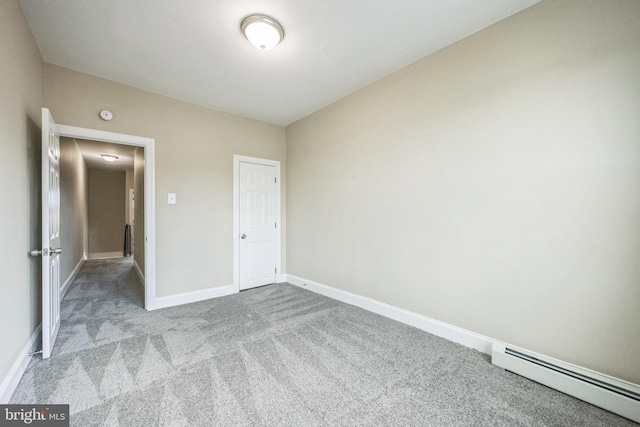 unfurnished bedroom featuring a closet, light colored carpet, and baseboard heating