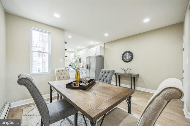 dining area with baseboard heating and light hardwood / wood-style floors