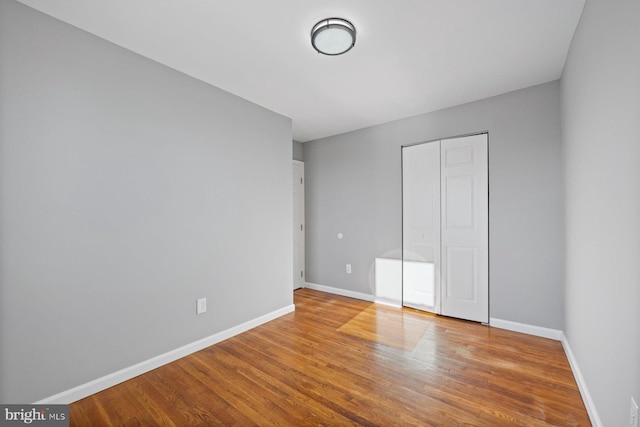 unfurnished bedroom with a closet and hardwood / wood-style flooring