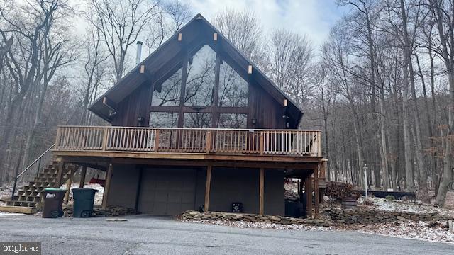 back of property with a garage and a deck