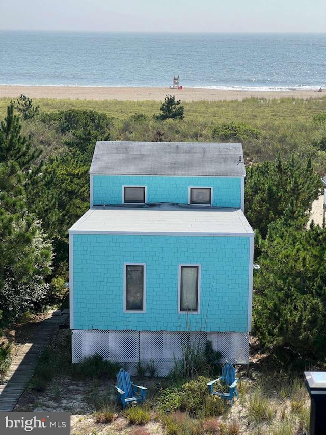 birds eye view of property featuring a water view and a beach view