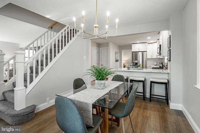 dining room with dark hardwood / wood-style floors and a notable chandelier