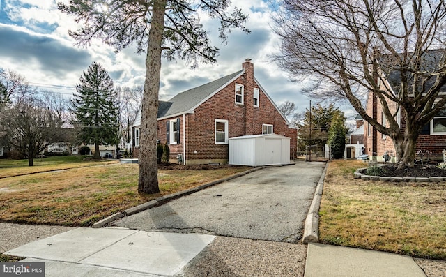 view of property exterior with a lawn and an outbuilding