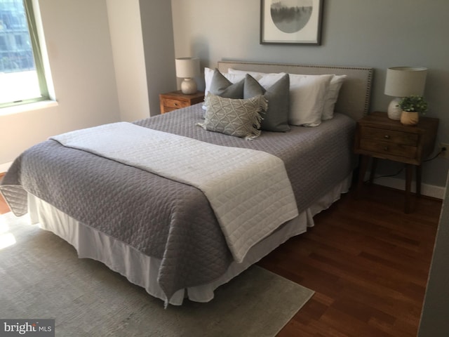 bedroom with dark hardwood / wood-style floors