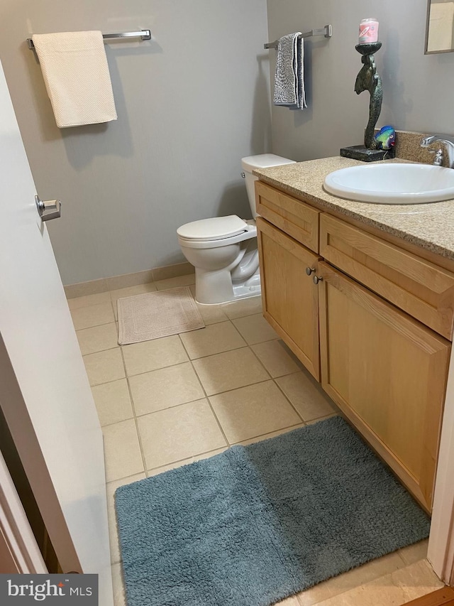 bathroom featuring tile patterned floors, vanity, and toilet