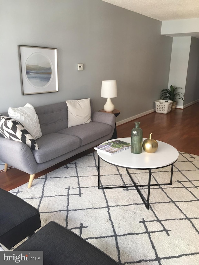 living room featuring wood-type flooring and a textured ceiling