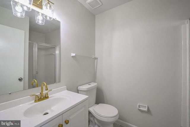 bathroom with vanity, toilet, and a shower with shower door