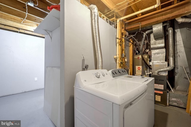 clothes washing area featuring water heater and washing machine and clothes dryer