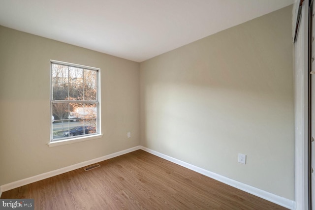 unfurnished room with wood-type flooring