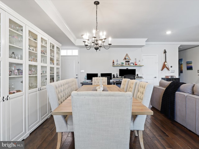 dining space featuring a raised ceiling, crown molding, a chandelier, and dark hardwood / wood-style floors