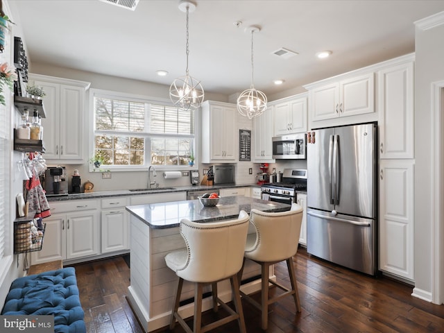 kitchen featuring white cabinets, a center island, and stainless steel appliances