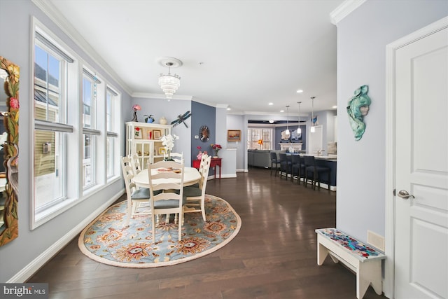 dining room with dark wood-type flooring, an inviting chandelier, and crown molding