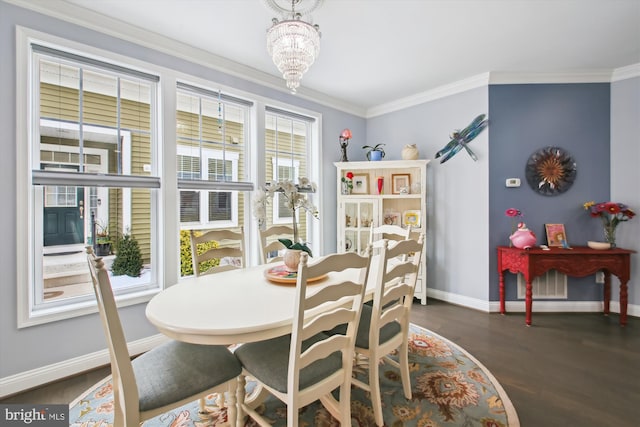 dining room featuring crown molding, dark hardwood / wood-style flooring, and an inviting chandelier