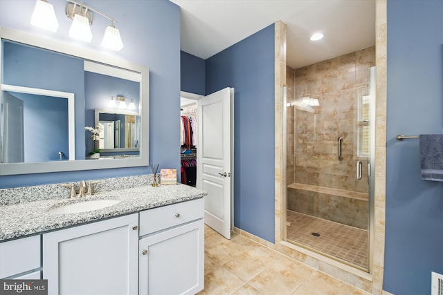 bathroom featuring walk in shower, vanity, and tile patterned flooring