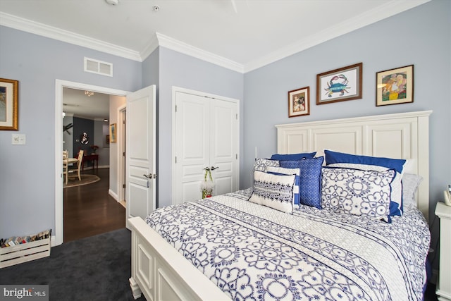 bedroom with a closet, crown molding, and dark colored carpet