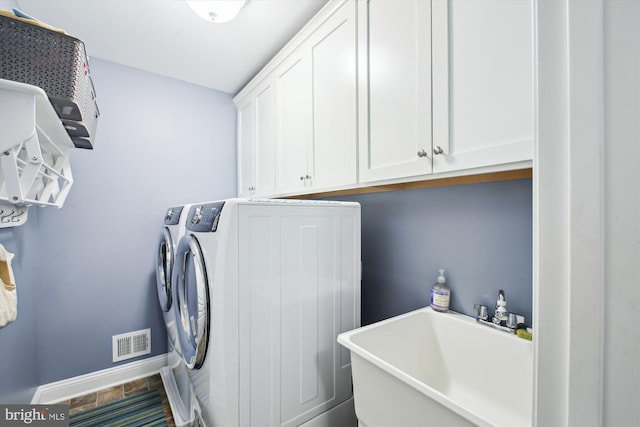 washroom featuring cabinets, independent washer and dryer, and sink