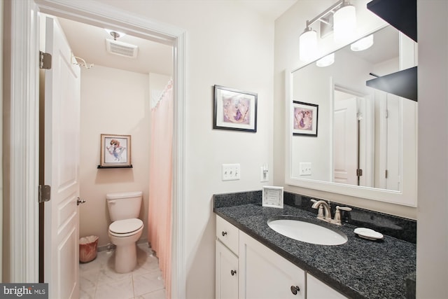 bathroom with toilet, tile patterned flooring, and vanity