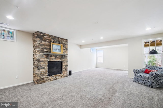 living room featuring a fireplace, a wealth of natural light, and carpet flooring