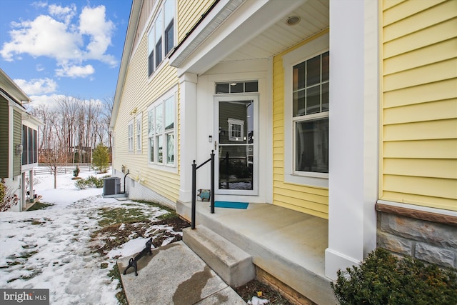 snow covered property featuring central AC unit