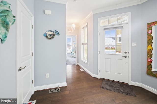 entryway with a chandelier, dark hardwood / wood-style floors, and ornamental molding