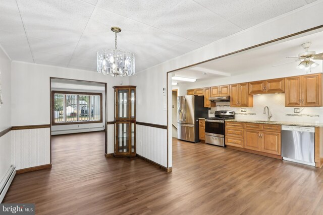 kitchen featuring light stone countertops, sink, hanging light fixtures, stainless steel appliances, and ceiling fan with notable chandelier