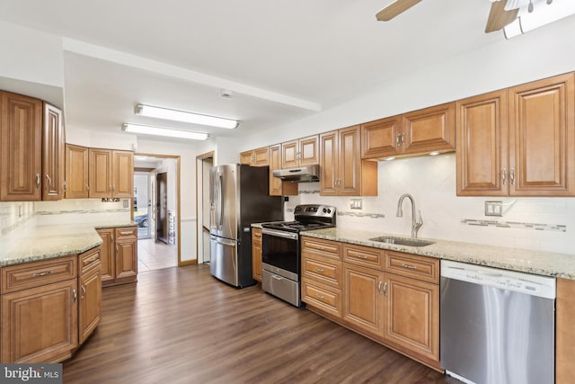 kitchen with ceiling fan, sink, light stone counters, and stainless steel appliances