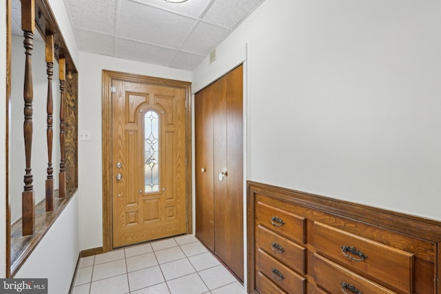 foyer entrance with a paneled ceiling and light tile patterned floors