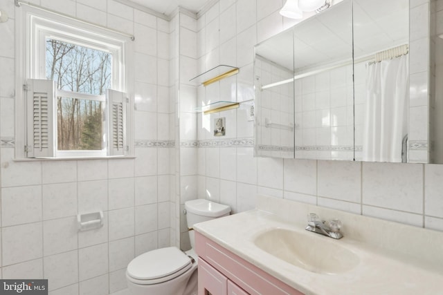 bathroom with backsplash, vanity, tile walls, toilet, and curtained shower