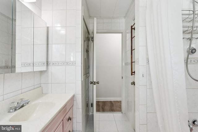 bathroom with tile patterned flooring, vanity, a shower with curtain, and tile walls