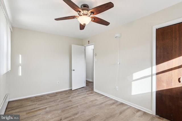 unfurnished bedroom featuring ceiling fan, a closet, light wood-type flooring, and a baseboard radiator