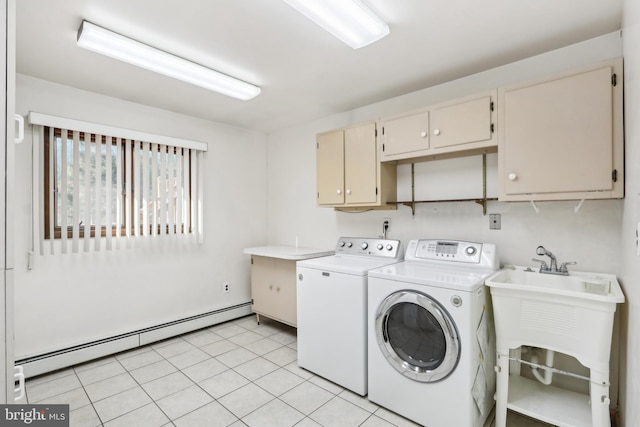 laundry area featuring washing machine and clothes dryer, sink, cabinets, a baseboard heating unit, and light tile patterned floors